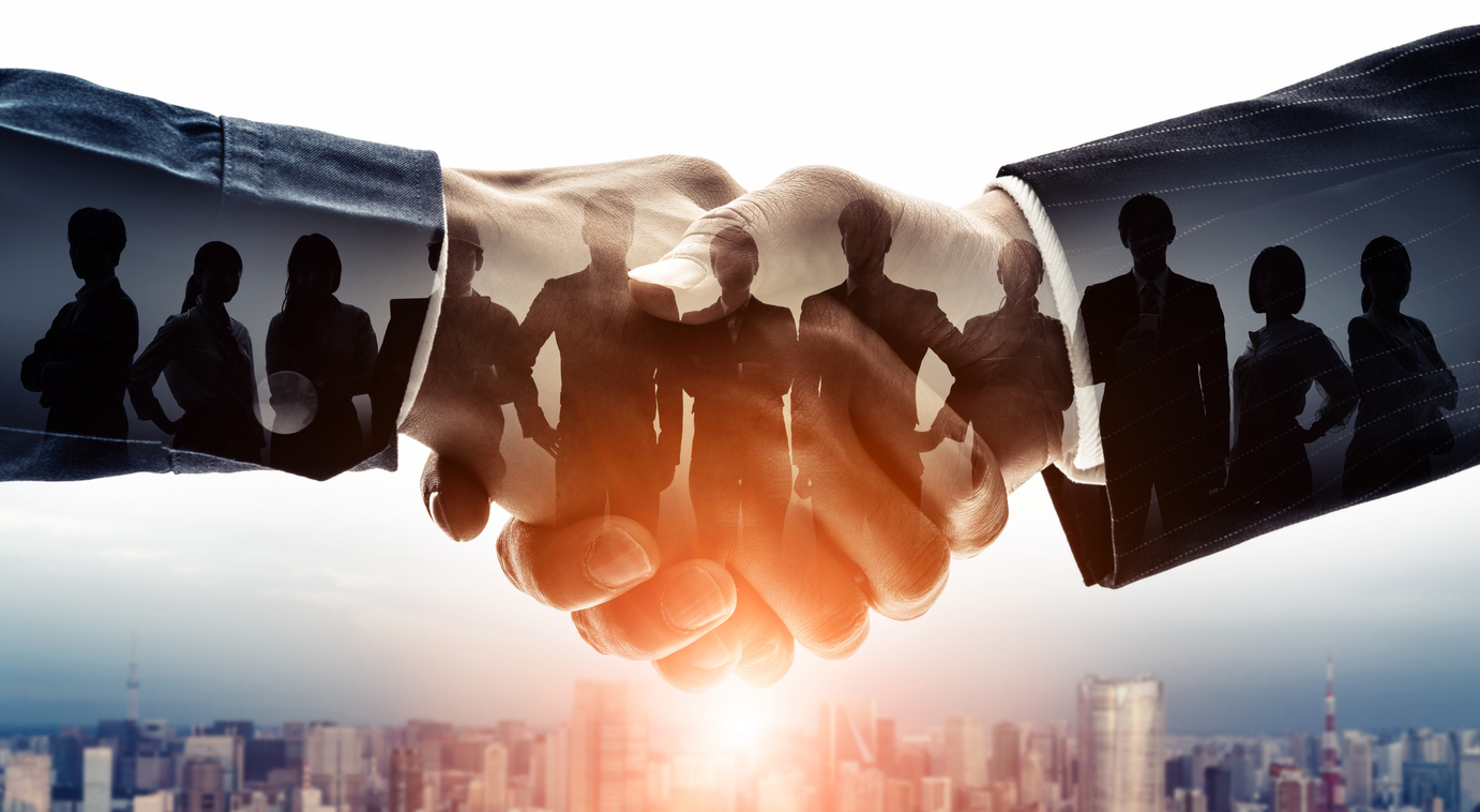 Business professionals shaking hands completing a trade sale transaction - Morphose Capital Partners advisory services